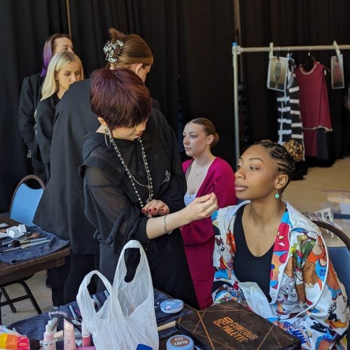 Model and makeup artist backstage at fashion show