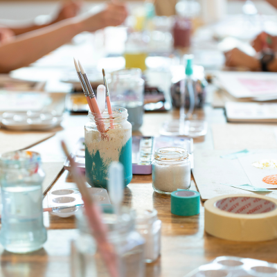 Table full of paintbrushes and art supplies