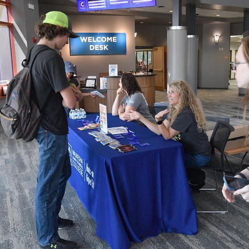 Staff greeting students at welcome table