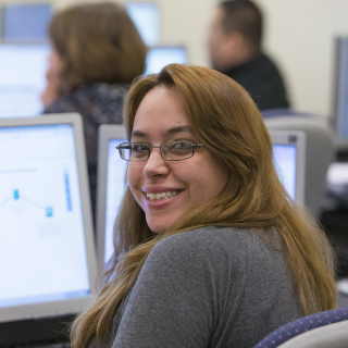 Female student smiling at computer