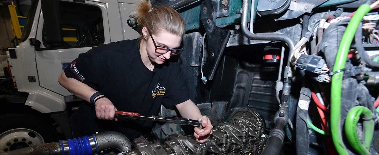 Female student servicing diesel engine