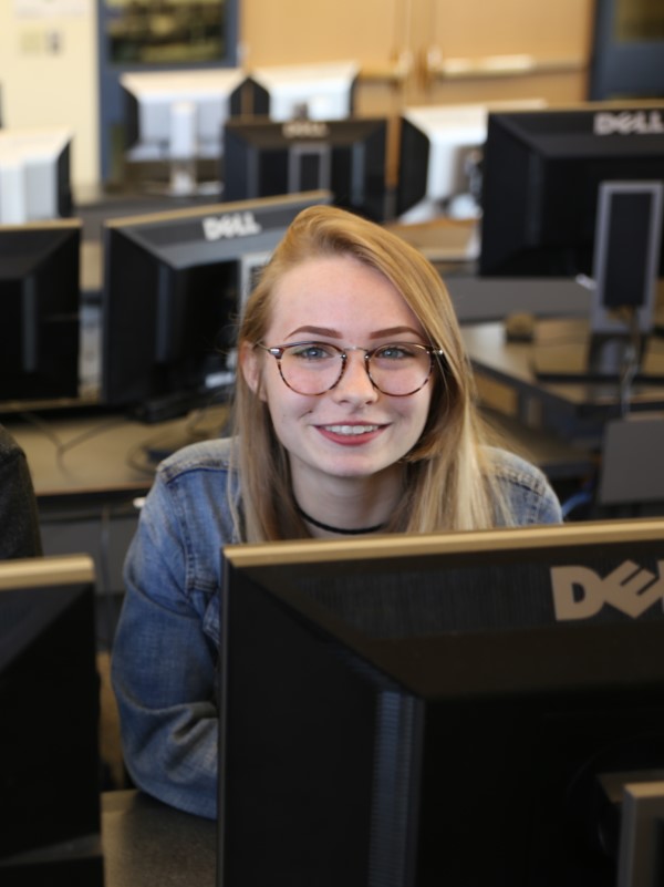Female student at computer smiling