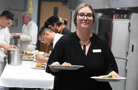 Hospitality student with tray of food