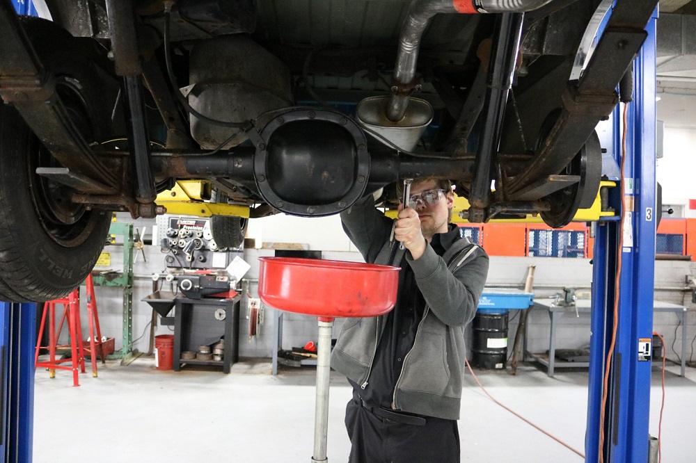 Student changing car oil