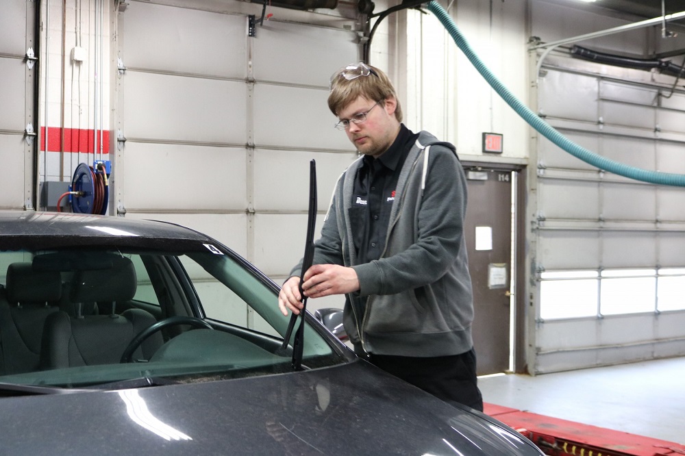 Student checking car wiper blades